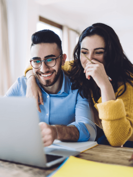 Couple happily using laptop